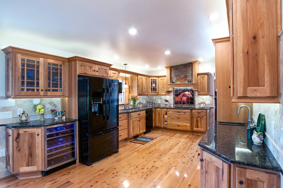 large open kitchen with old world cabinets and black countertops