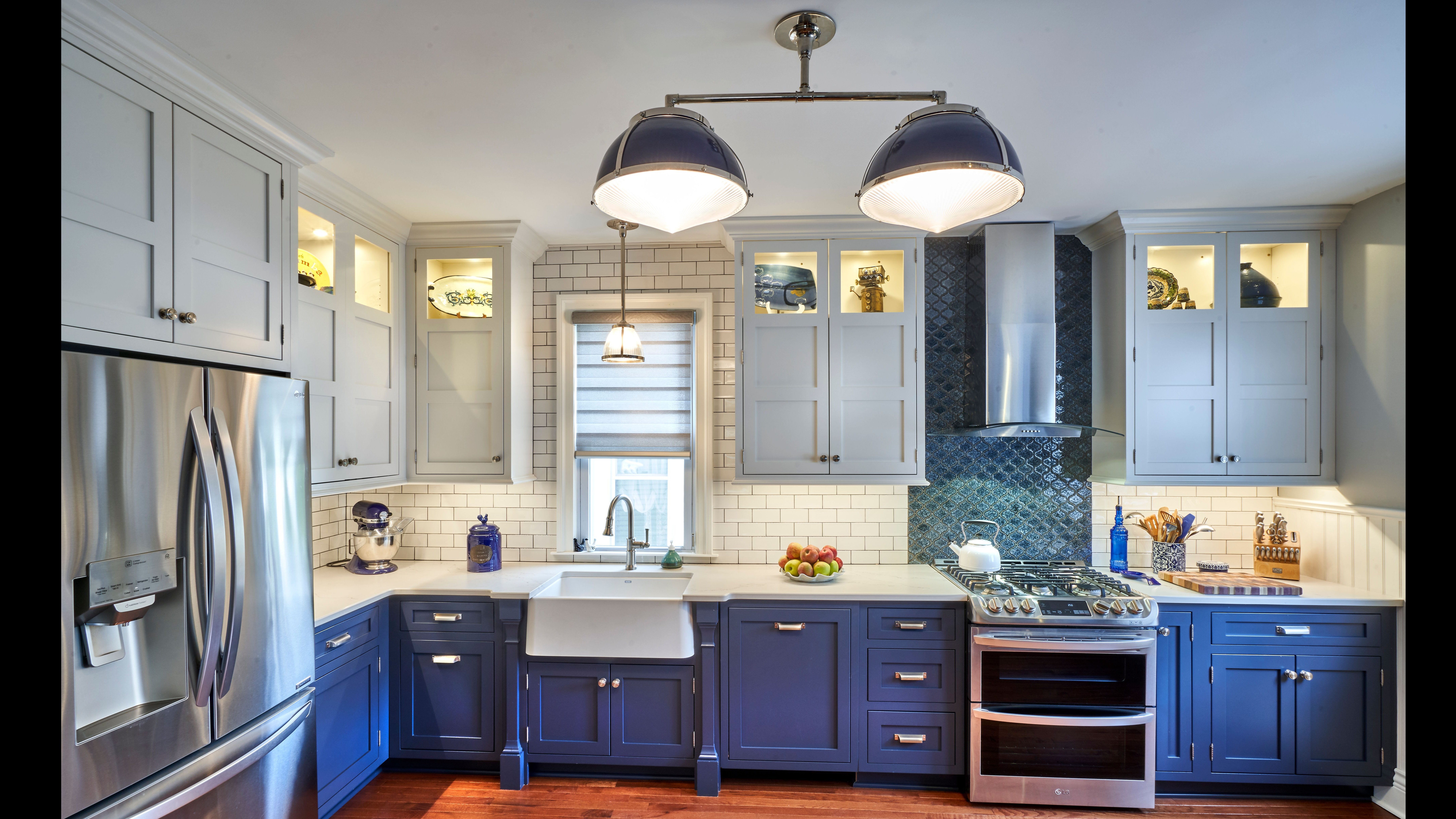 modern kitchen with blue bottom cabinets, white top cabinets and farmhouse sink