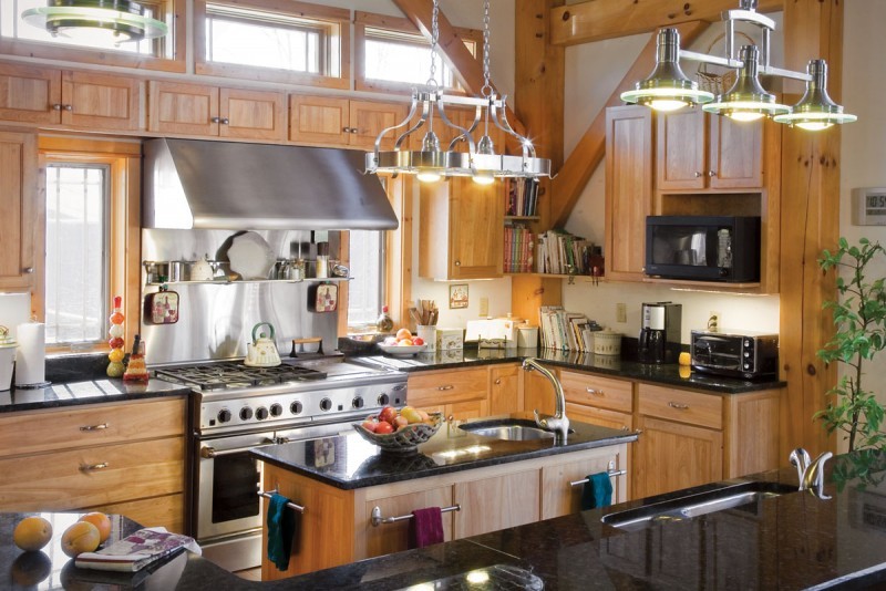 large kitchen with bright windows, black counters and oak cabinets